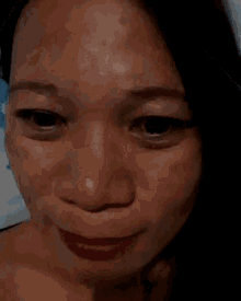 a close up of a woman 's face with a blue sky in the background