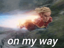 a woman in a superhero costume is flying through the air with the words on my way below her