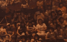 a crowd of people sitting in a dark room with balloons