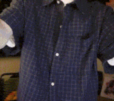 a man wearing a blue shirt with white buttons on the sleeves