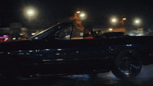 a man is driving a black car at night