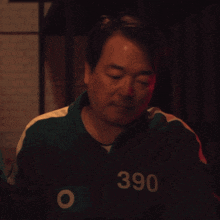 a man wearing a black and green jacket with the number 390 on it