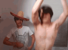 a shirtless man wearing a sombrero stands next to a shirtless man wearing a shirt with a bear on it