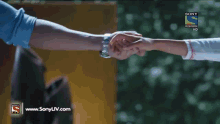 a man in a blue shirt is looking at another man in a sony television ad