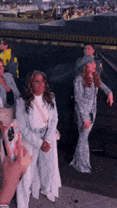 a woman in a cowboy hat stands next to another woman