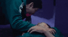 a man is holding a dead woman 's head in his arms in a dark room .