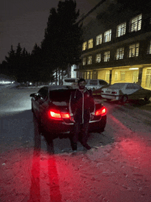 a man stands in front of a car that has the word bmw on the side