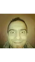 a man with a beard is making a funny face while wearing a fur coat .