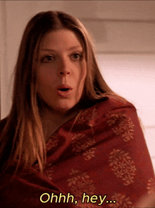 a woman is wrapped in a red scarf and says ohhh hey