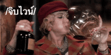 a woman in a red hat is drinking a large glass of wine .