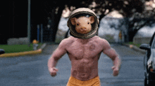 a shirtless man with a pig on his head wearing a helmet