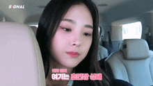 a woman sitting in the back seat of a car with the word signal on the bottom right