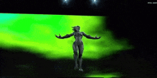 a woman is standing in front of a green screen with her arms outstretched