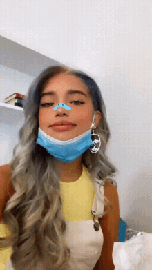 a woman wearing a blue face mask with a blue nose ring