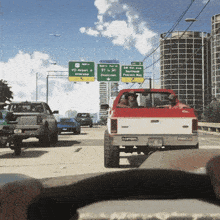 a red truck is driving down a highway with a green sign that says vc airport