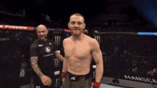 a man in a fc belt stands in front of a man in a black shirt