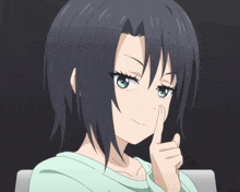 a girl with dark hair and blue eyes holds her finger to her lips
