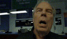 a close up of a man 's face with his mouth open in a room