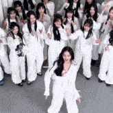 a group of women in white jumpsuits are dancing