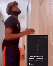 a man is standing next to a sign that says thank you for the venom 2025 mix