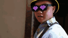a man wearing heart shaped sunglasses and a yellow hat