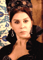 a woman with a crown on her head and earrings on her ear