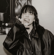 a black and white photo of a woman wearing a leather jacket
