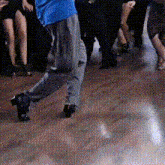 a man in a blue shirt is dancing on a dance floor