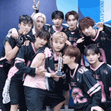 a group of young men are posing for a picture and one has a trophy that says hot stage on it