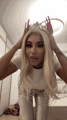 a woman wearing a tiara and a white shirt