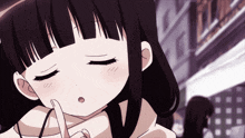 a close up of a girl with a finger on her mouth