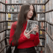 a woman in a red sweater is holding a book that says kid