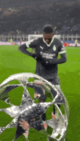 a soccer player in a black jersey with emirates on it