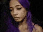 a woman with purple hair is looking down at something in a pixelated image .