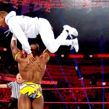 a wrestler is holding another wrestler up in the air during a match