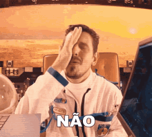a man in a space suit covering his face with his hand and the word não written on it