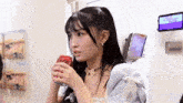 a young woman is drinking a can of coca cola from a can .