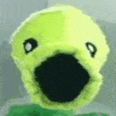 a close up of a yellow stuffed animal with a black beak and eyes .