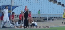 a group of soccer players are sitting in a dugout on a soccer field .