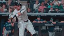a new york yankees player swings his bat at a ball