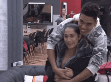 a man is hugging a woman in a room with a sign that says sala on it