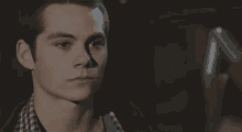 a close up of a young man 's face in a dark room with a shadow on his face .