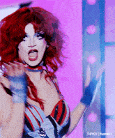 a woman with red hair is making a funny face with her mouth open .