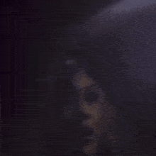 a blurred image of a person sitting in a dark room