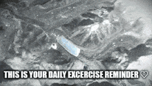 a black and white photo of a bottle of water with the words `` this is your daily excercise reminder '' written below it .