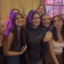 a group of women are posing for a picture and one of them has purple hair
