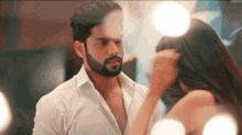 a man and a woman are looking at each other in front of a mirror in a room .