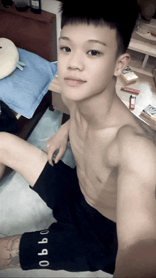 a shirtless young man is taking a selfie with a pair of shorts that say obbo