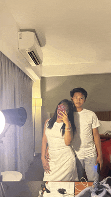 a man and a woman are posing for a picture in a hotel room