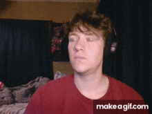 a man wearing headphones and a red shirt has a make a gif.com watermark on the bottom right
